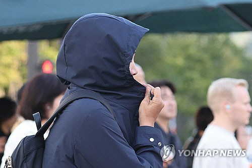 쌀쌀한 날씨를 보인 2일 오전 서울 종로구 광화문네거리에서 한 시민이 외투 모자를 뒤집어쓰고 있다. [연합뉴스]